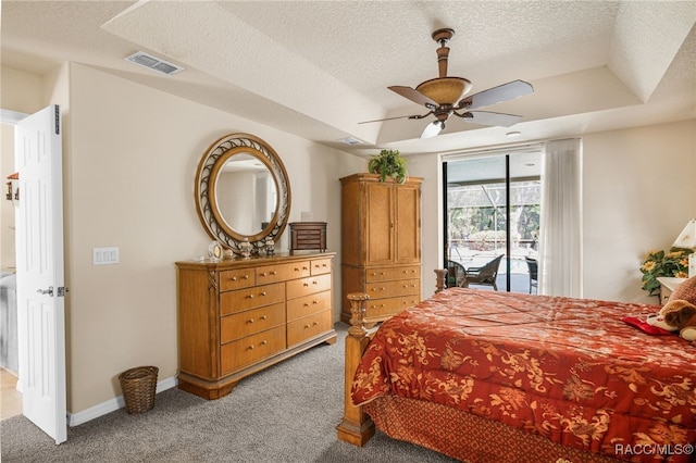 bedroom featuring visible vents, carpet flooring, a tray ceiling, and access to outside