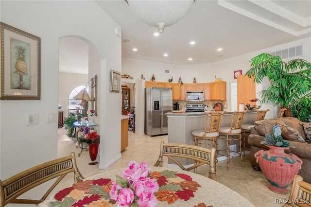 interior space featuring visible vents, baseboards, light tile patterned floors, recessed lighting, and arched walkways