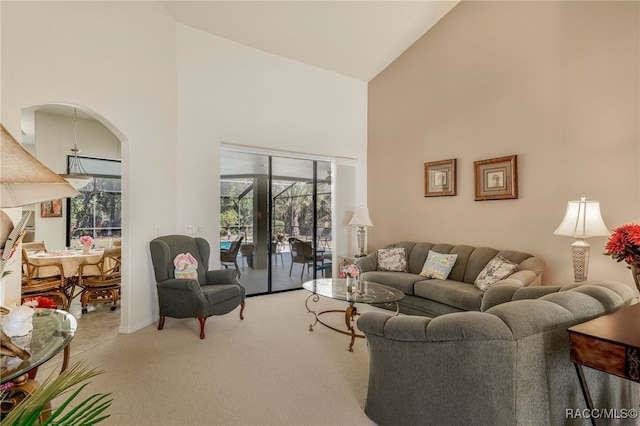 carpeted living room featuring plenty of natural light and high vaulted ceiling