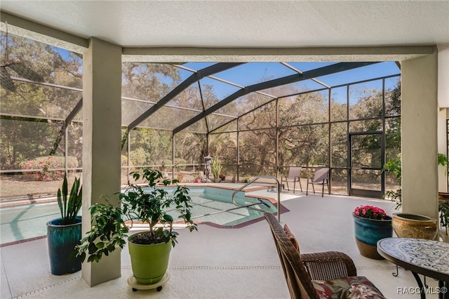 pool featuring glass enclosure and a patio area