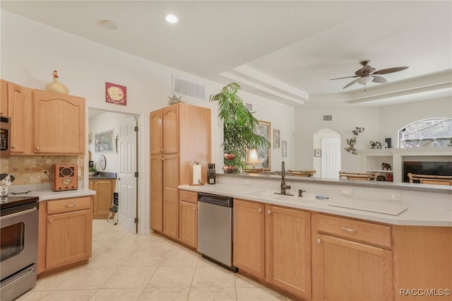 kitchen featuring arched walkways, stainless steel appliances, light countertops, and ceiling fan