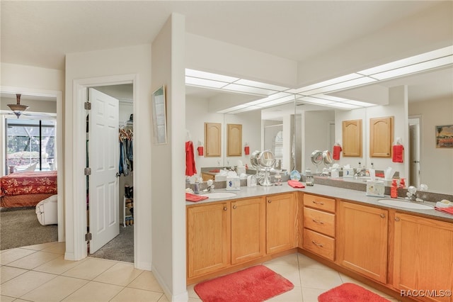 full bathroom featuring double vanity, tile patterned floors, a spacious closet, and a sink