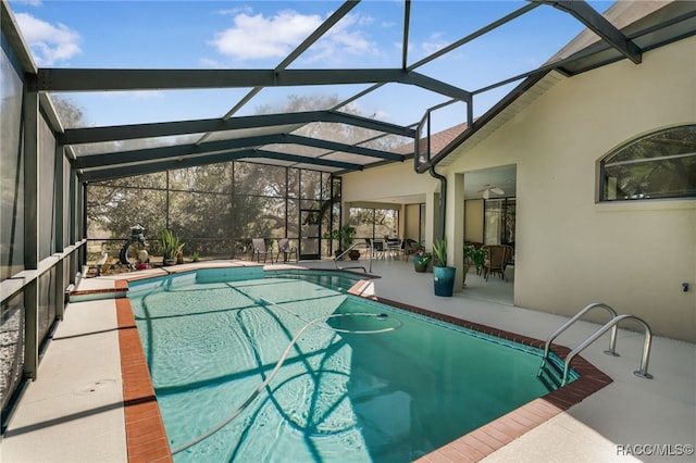 pool with glass enclosure and a patio area