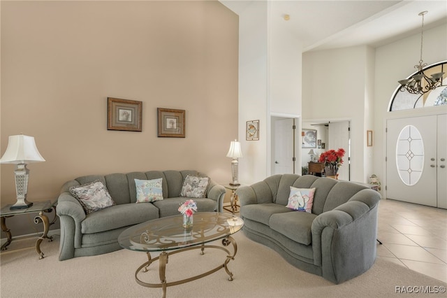 living room featuring light tile patterned floors, a high ceiling, and an inviting chandelier