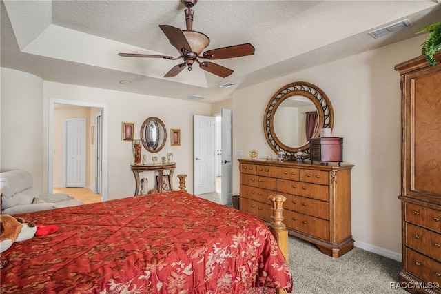 bedroom featuring visible vents, light carpet, and a textured ceiling