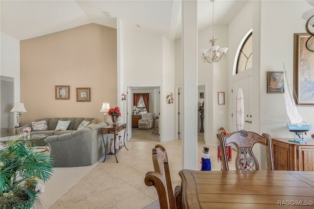 dining room with light tile patterned flooring, high vaulted ceiling, and an inviting chandelier