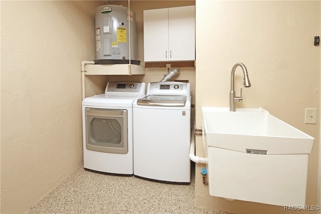 laundry area with washing machine and clothes dryer, electric water heater, and cabinets