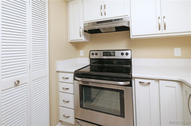 kitchen featuring white cabinetry and electric stove