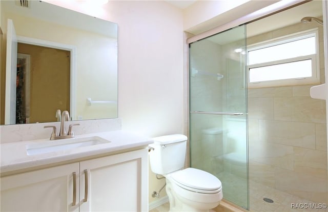 bathroom with vanity, a shower with shower door, and toilet