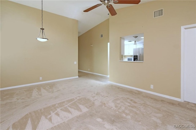 spare room featuring light colored carpet, high vaulted ceiling, and ceiling fan