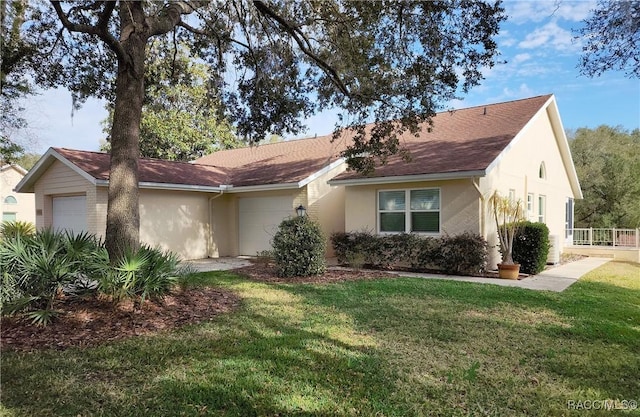 ranch-style house featuring a garage and a front lawn