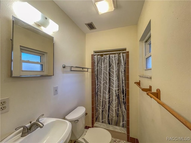 full bathroom featuring toilet, visible vents, a sink, and a shower with shower curtain