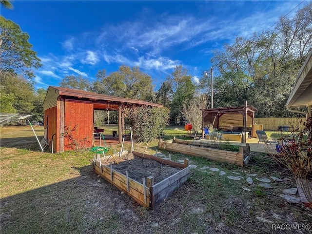 view of playground with an outbuilding, a storage unit, a lawn, fence, and a garden