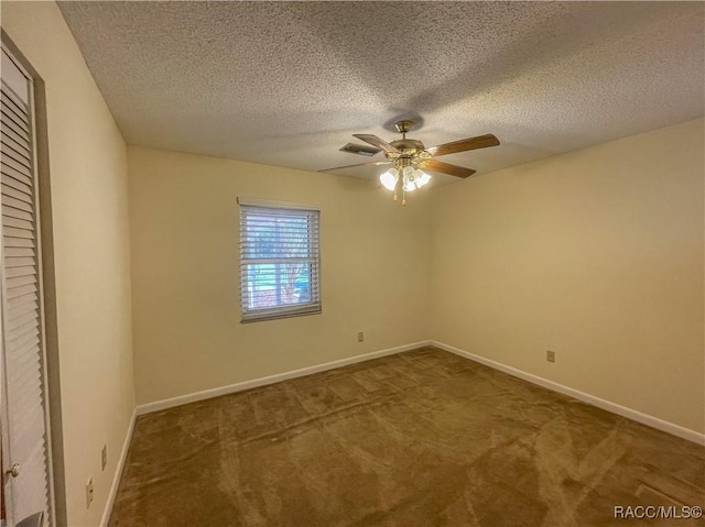 carpeted empty room with a ceiling fan, visible vents, a textured ceiling, and baseboards