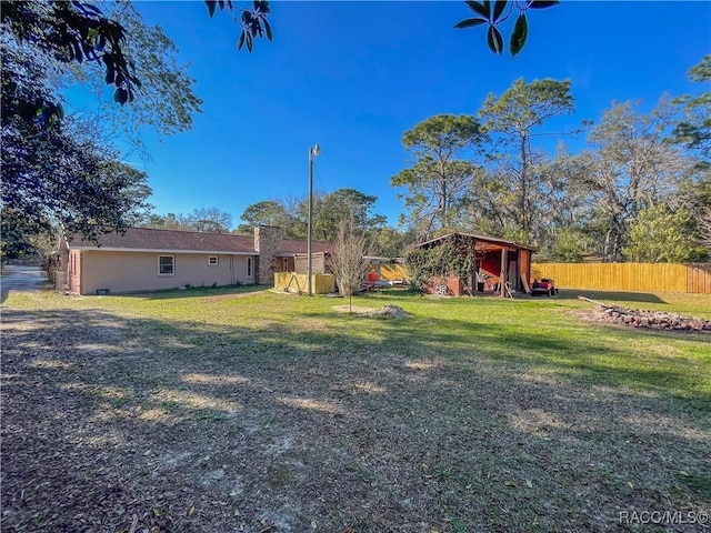 view of yard featuring fence and an outdoor structure