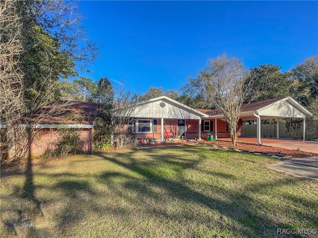 ranch-style home featuring an attached carport and a front yard