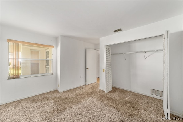 unfurnished bedroom featuring carpet and a closet