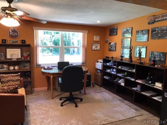 office area with a textured ceiling and ceiling fan