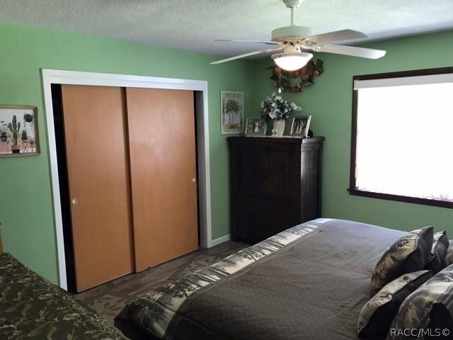 bedroom featuring a textured ceiling, ceiling fan, and a closet