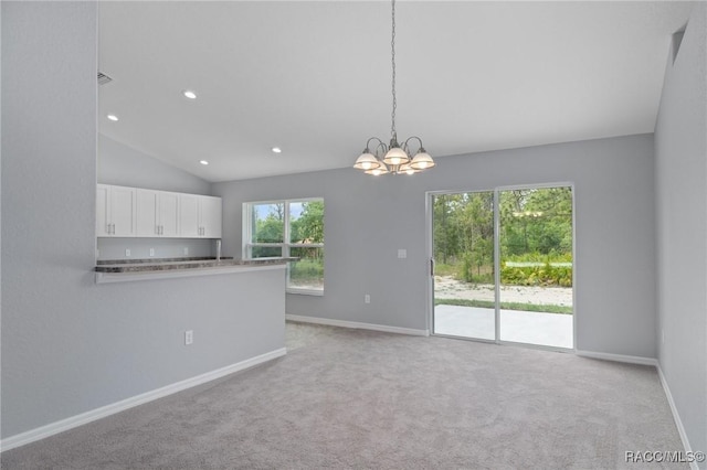 interior space with lofted ceiling, light colored carpet, and an inviting chandelier