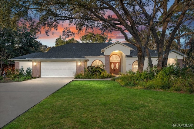 view of front facade featuring a lawn and a garage