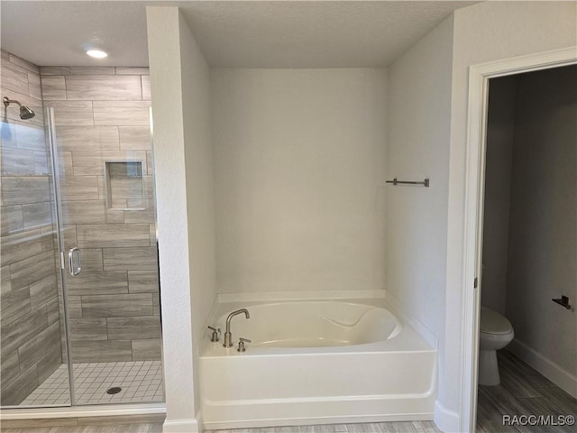 bathroom featuring toilet and shower with separate bathtub