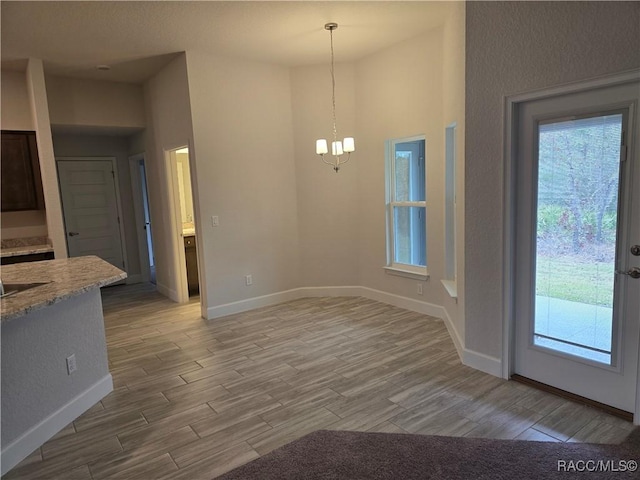 unfurnished dining area with a healthy amount of sunlight and an inviting chandelier