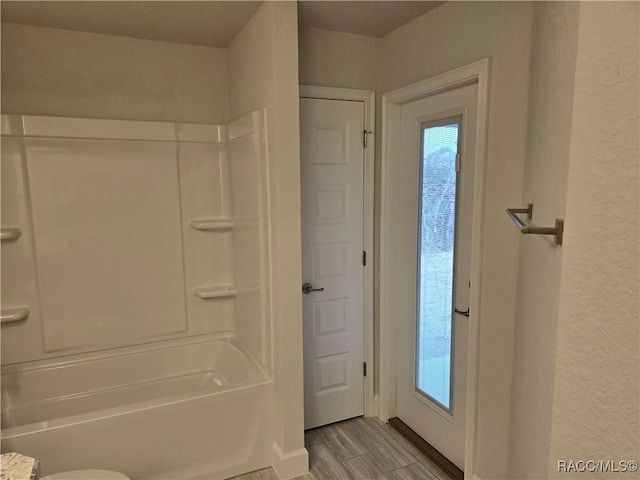 bathroom featuring shower / tub combination and toilet