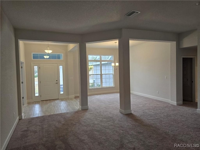 entryway with carpet floors and a textured ceiling