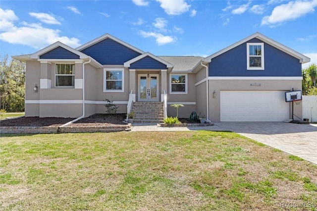 view of front facade with an attached garage, french doors, decorative driveway, stucco siding, and a front lawn