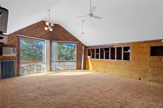 unfurnished living room featuring carpet floors, ceiling fan, wooden walls, and high vaulted ceiling