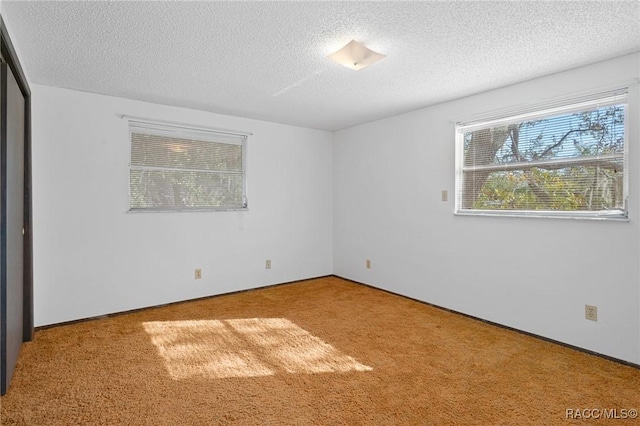 unfurnished bedroom with carpet and a textured ceiling