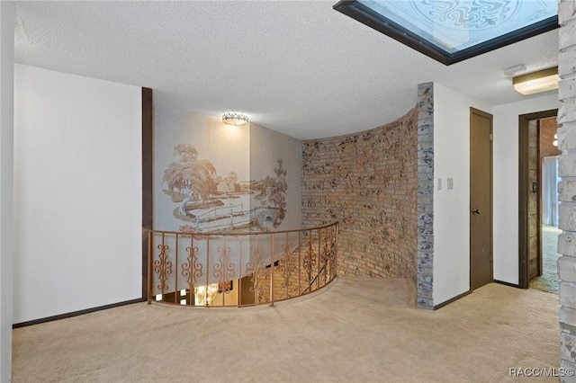 hall featuring light colored carpet and a textured ceiling