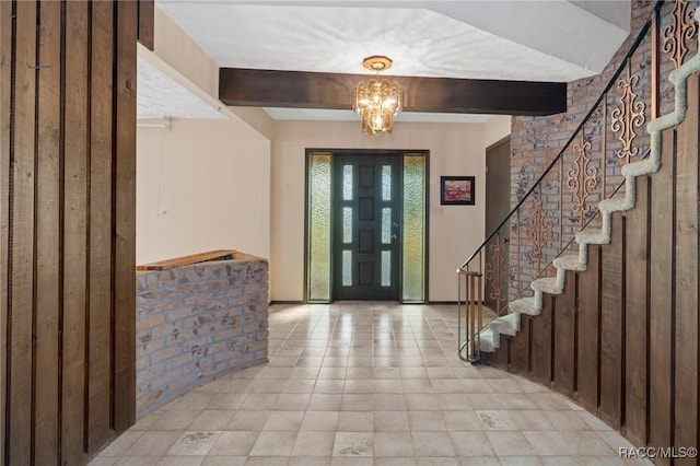 foyer with beam ceiling and a chandelier