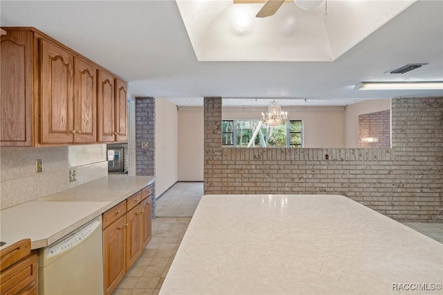 kitchen featuring dishwasher, brick wall, pendant lighting, and ceiling fan with notable chandelier