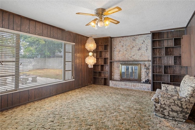 unfurnished living room with a textured ceiling, carpet floors, and wood walls