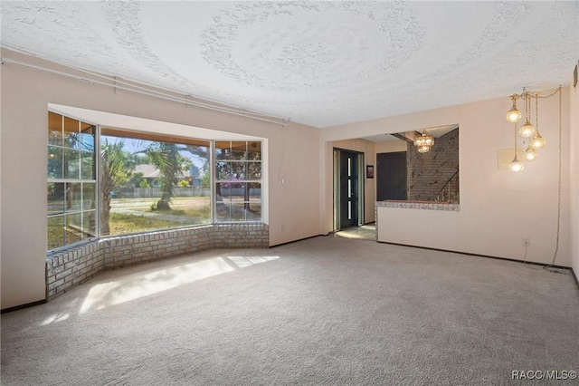 carpeted empty room featuring a textured ceiling