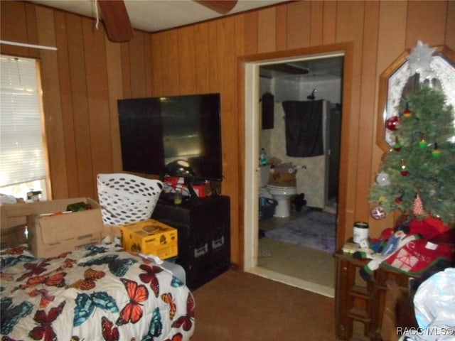 bedroom featuring ensuite bathroom and wood walls