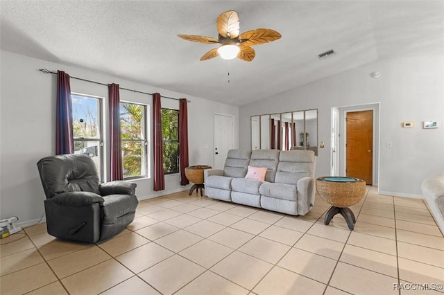 living room with light tile patterned floors, a textured ceiling, ceiling fan, and vaulted ceiling