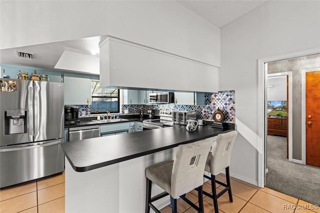 kitchen with dark countertops, light tile patterned floors, and stainless steel appliances