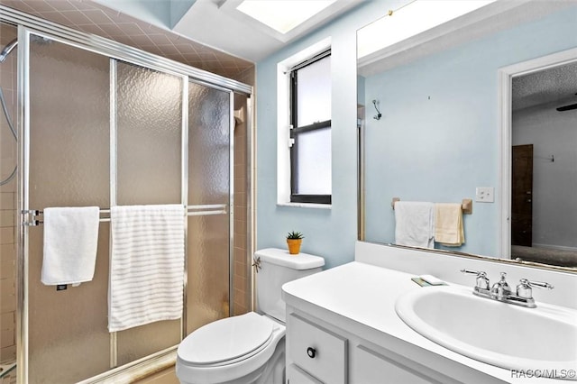 full bathroom featuring toilet, a stall shower, and vanity