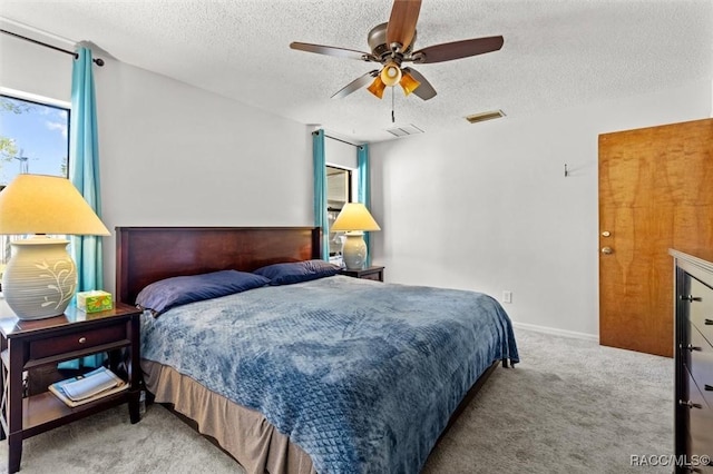 bedroom with carpet flooring, a textured ceiling, visible vents, and a ceiling fan