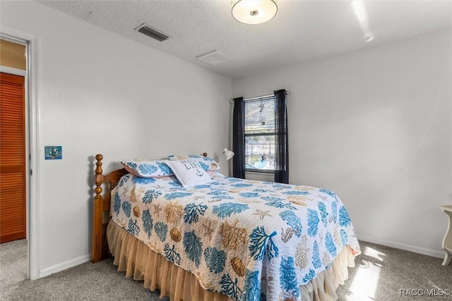 bedroom with carpet flooring, baseboards, visible vents, and a textured ceiling