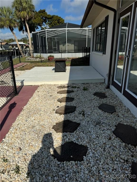 view of yard featuring a deck and a lanai