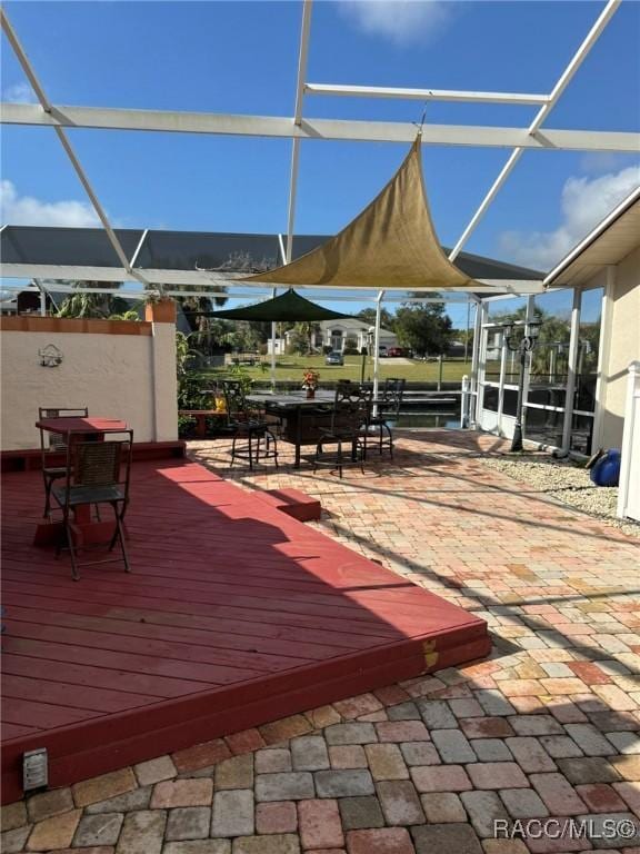 wooden terrace with glass enclosure and a patio area