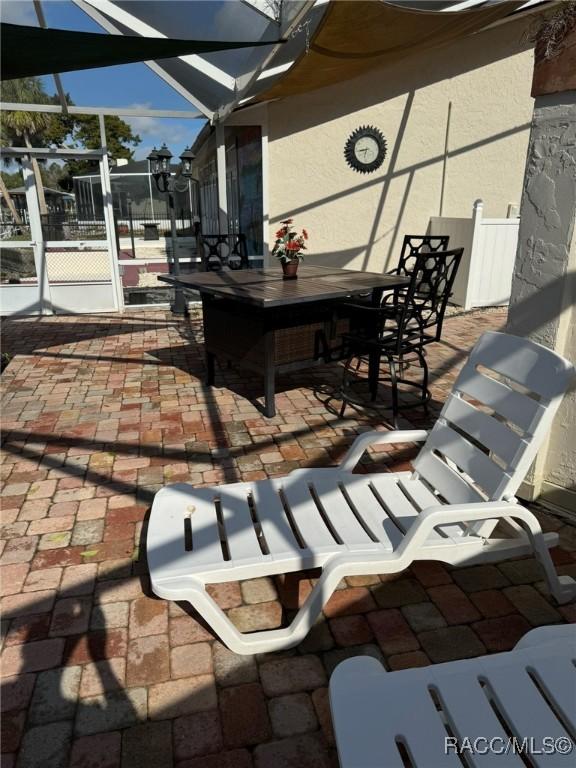 view of patio featuring a lanai