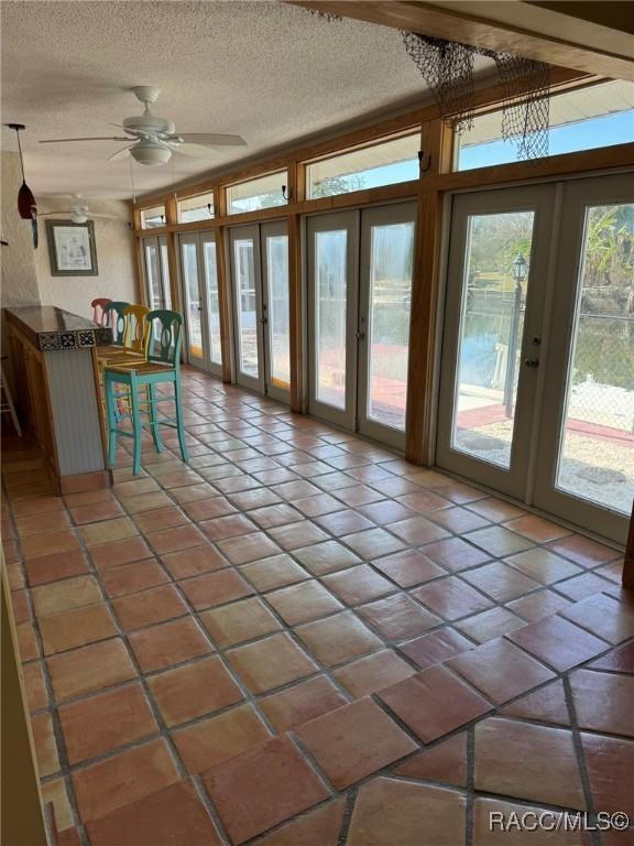 doorway with ceiling fan, french doors, and a textured ceiling