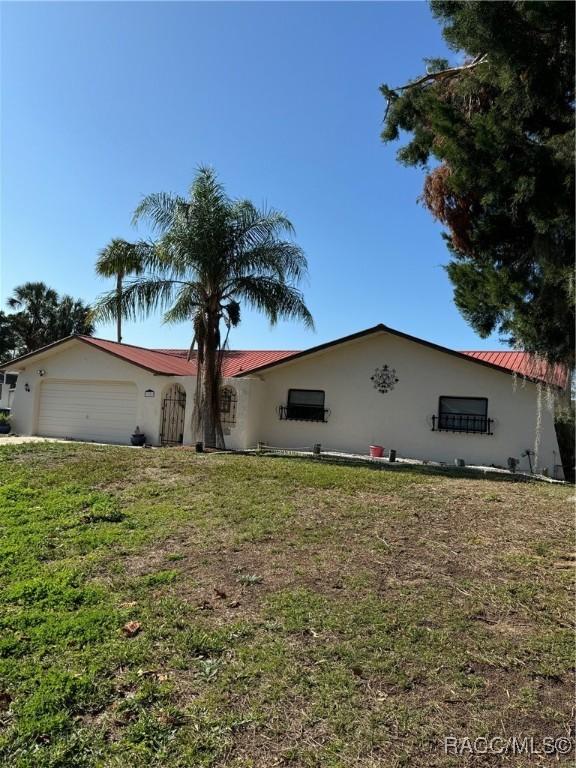 ranch-style house with a garage and a front lawn