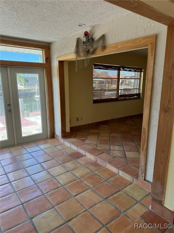 interior space featuring french doors and a textured ceiling