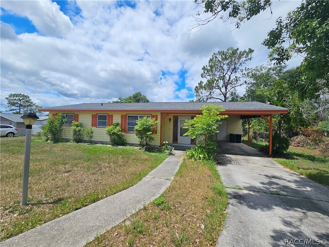 single story home featuring a front lawn and a carport